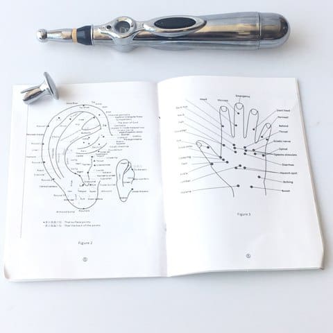 Stylo d'acupuncture électrique AcuPen et guide avec les points d'acupuncture et méridiens des mains et des oreilles.