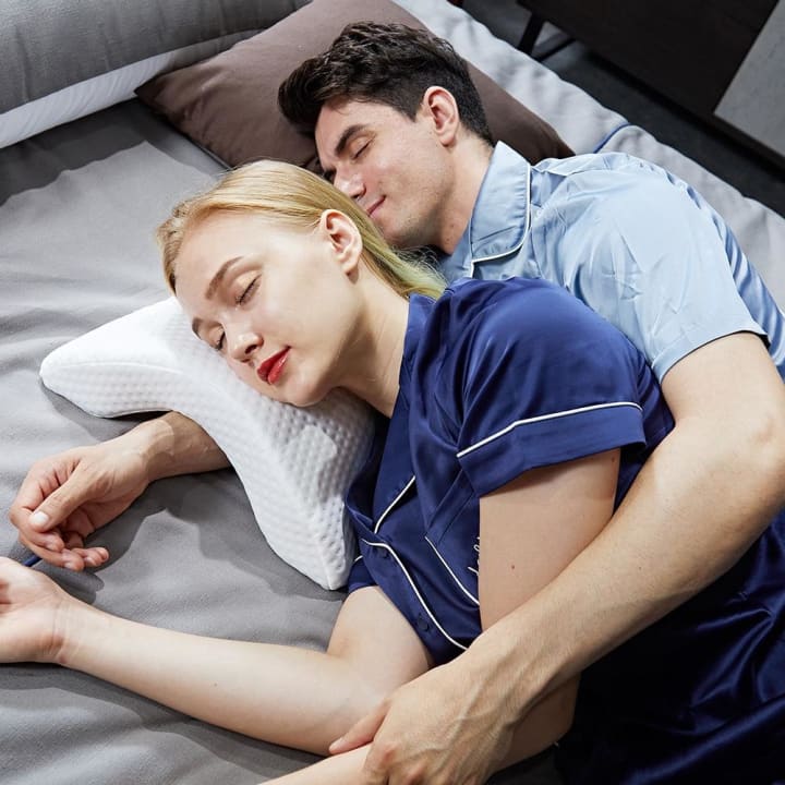 Oreiller à mémoire de forme courbe - Couple dormant sur l'oreiller avec homme passant le bras en dessous