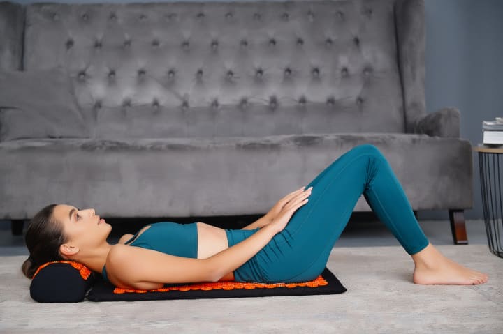 Tapis d’acupuncture Akumata Soft - Femme qui relaxe son dos couchée sur le matelas